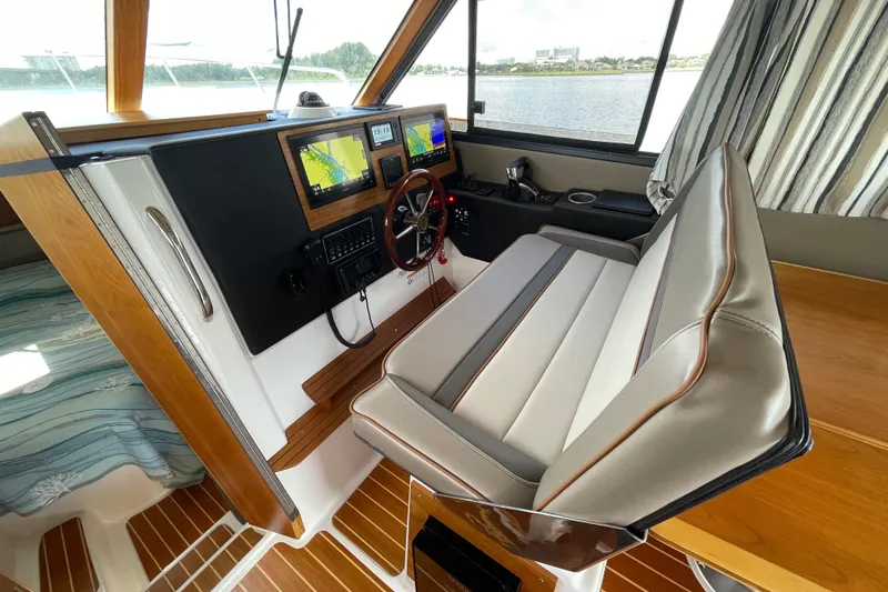 Motivated Yacht Photos Pics Interior helm of 2022 Cutwater C-32 CB boat with navigation screens and leather seating.