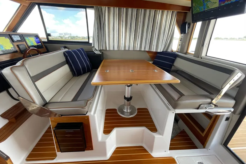 Motivated Yacht Photos Pics 2022 Cutwater C-32 CB interior with seating, table, and navigation screens.