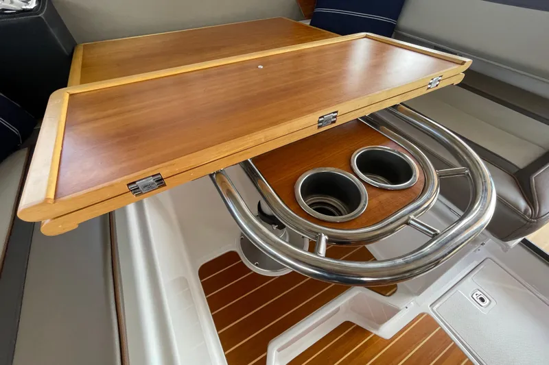 Motivated Yacht Photos Pics 2022 Cutwater C-32 CB interior with wooden table and stainless steel cup holders.
