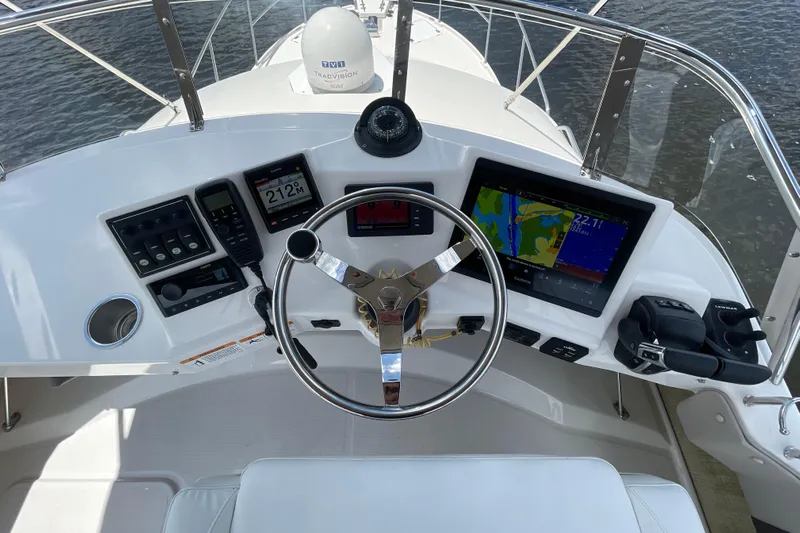 Motivated Yacht Photos Pics 2022 Cutwater C-32 CB helm with navigation screens and controls on a sunny day.