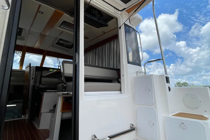 Motivated Yacht Photos Pics 2022 Cutwater C-32 CB boat interior with open door, showcasing seating and sky view.