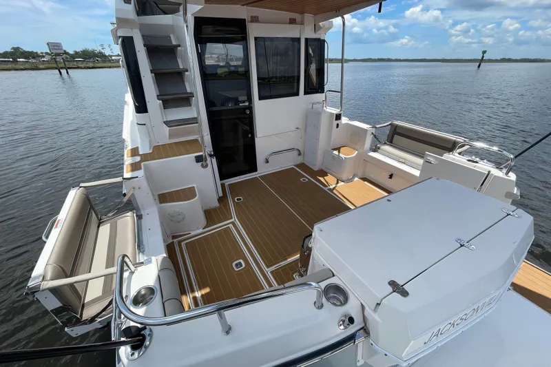 Motivated Yacht Photos Pics 2022 Cutwater C-32 CB boat deck with seating, wood flooring, and water view.