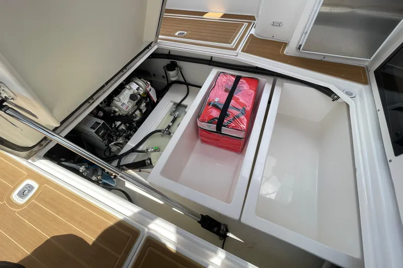 Motivated Yacht Photos Pics 2022 Cutwater C-32 CB engine compartment with storage and equipment, featuring a red bag.