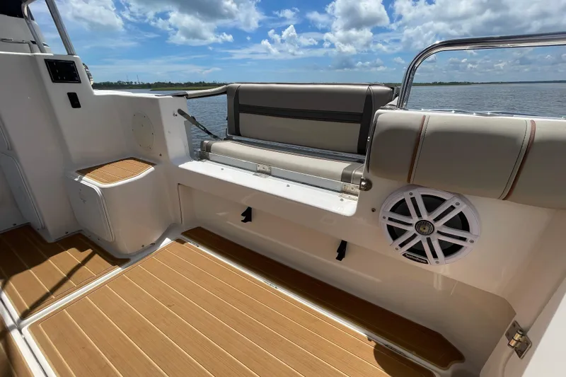 Motivated Yacht Photos Pics 2022 Cutwater C-32 CB boat interior with cushioned seating and marine speaker.