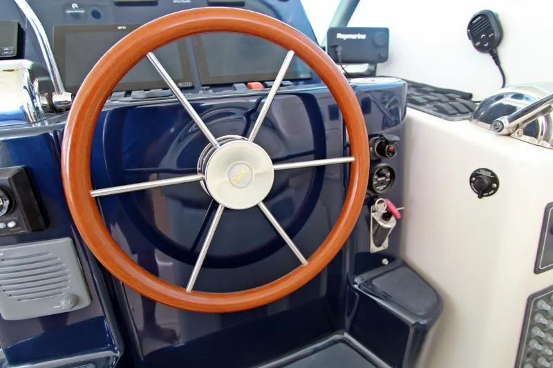  Yacht Photos Pics Steering wheel of a 2005 Tiara Yachts 3600 Sovran, featuring a wooden rim and modern controls.