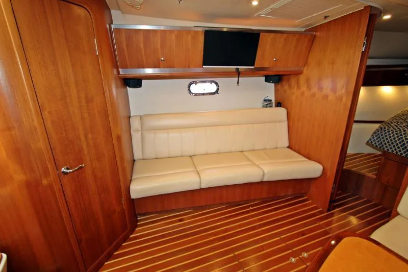  Yacht Photos Pics 2005 Tiara Yachts 3600 Sovran interior with wooden cabinetry, beige seating, and striped flooring.