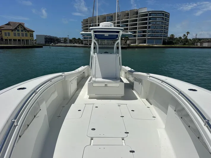  Yacht Photos Pics 2012 Yellowfin 36 Offshore boat on water, modern buildings in background.
