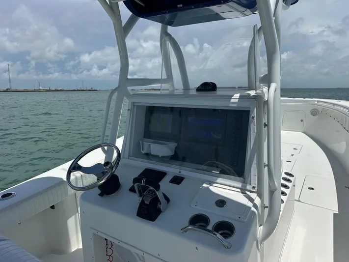  Yacht Photos Pics 2012 Yellowfin 36 Offshore boat dashboard with steering wheel and navigation system on open water.