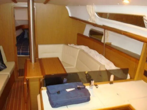 For Grins Too Yacht Photos Pics Interior of 2010 Jeanneau Sun Odyssey 36i sailboat with cozy seating and wooden finishes.