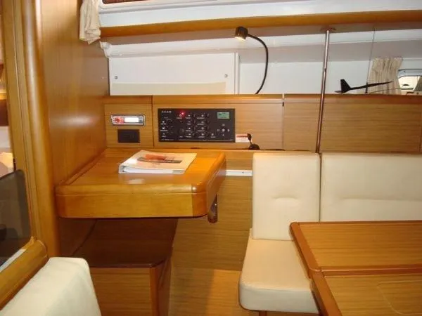 For Grins Too Yacht Photos Pics Interior of 2010 Jeanneau Sun Odyssey 36i yacht with navigation station and seating area.