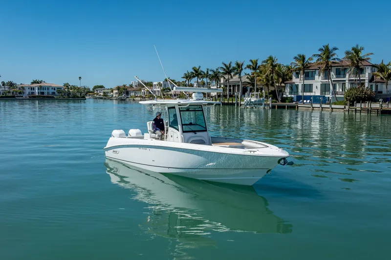 High Voltage Yacht Photos Pics 2013 Boston Whaler 320 Outrage boat on calm water near luxury waterfront homes.