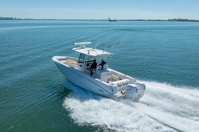 High Voltage Yacht Photos Pics 2013 Boston Whaler 320 Outrage cruising on open water, showcasing powerful twin engines.
