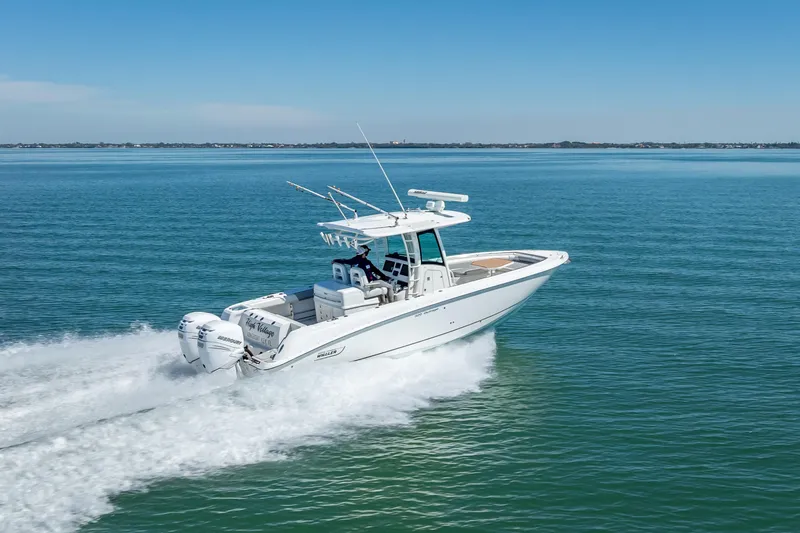 High Voltage Yacht Photos Pics 2013 Boston Whaler 320 Outrage cruising on open water, showcasing sleek design and powerful engines.