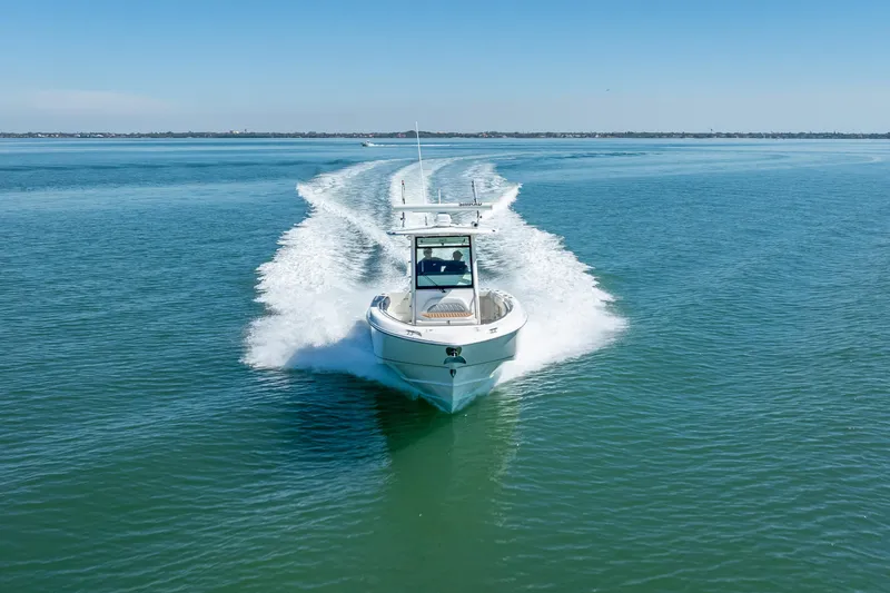 High Voltage Yacht Photos Pics 2013 Boston Whaler 320 Outrage cruising on open water, creating a wake.