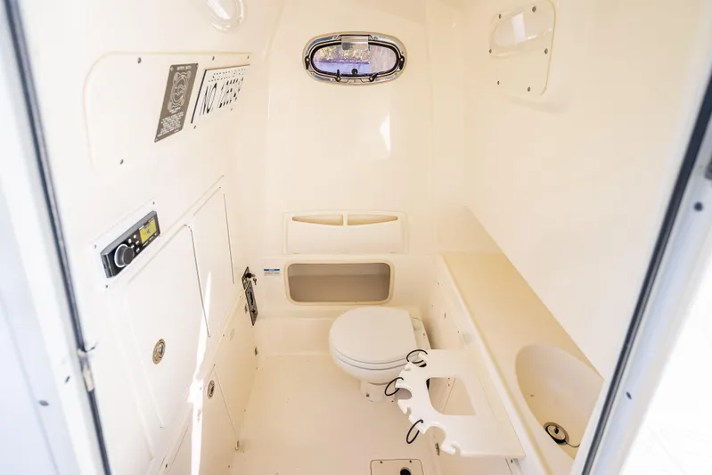 High Voltage Yacht Photos Pics 2013 Boston Whaler 320 Outrage cabin interior with toilet and storage compartments.