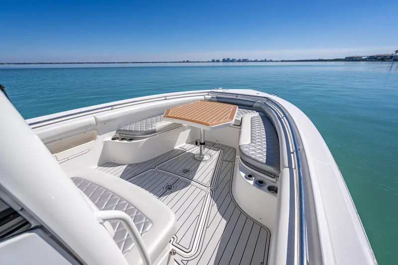 High Voltage Yacht Photos Pics 2013 Boston Whaler 320 Outrage boat interior with seating and table on calm water.