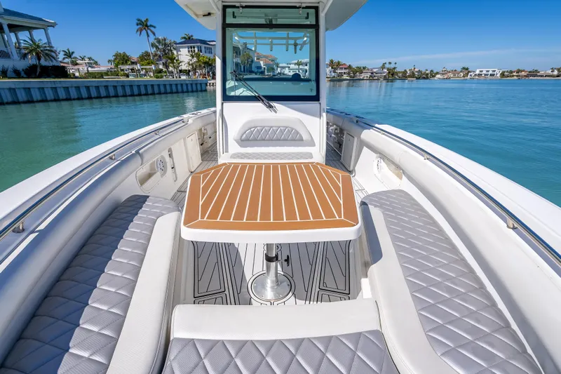 High Voltage Yacht Photos Pics 2013 Boston Whaler 320 Outrage boat interior with elegant seating and table on calm water.