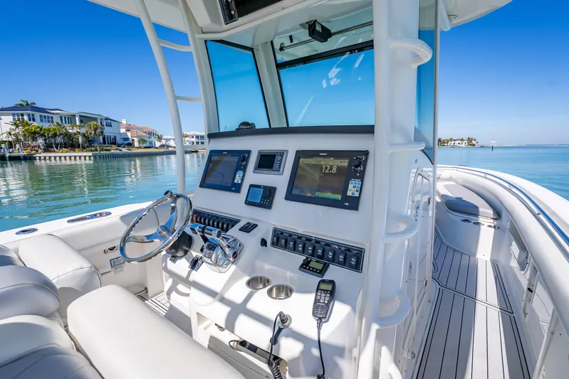 High Voltage Yacht Photos Pics 2013 Boston Whaler 320 Outrage boat interior with modern navigation equipment and waterfront view.