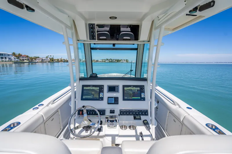 High Voltage Yacht Photos Pics 2013 Boston Whaler 320 Outrage helm with dual displays, steering wheel, and ocean view.