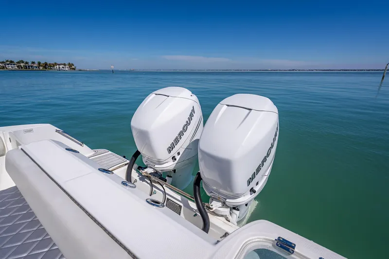 High Voltage Yacht Photos Pics 2013 Boston Whaler 320 Outrage with twin Mercury outboard engines on calm water.