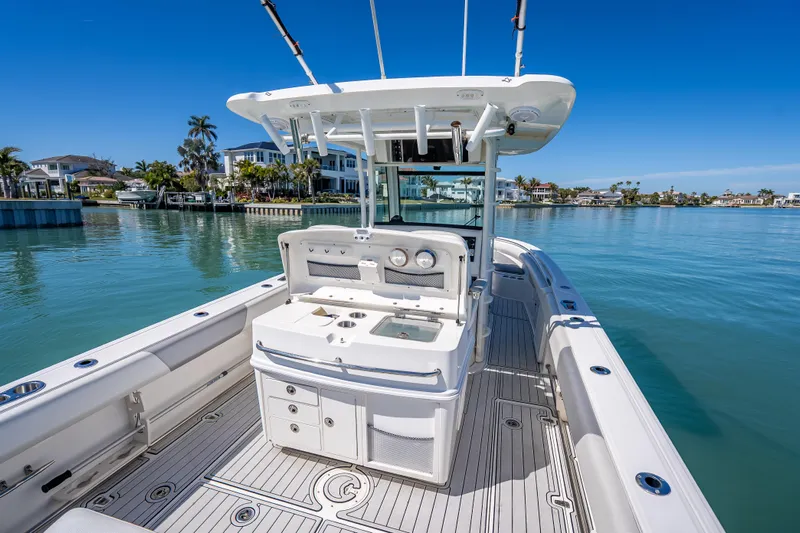 High Voltage Yacht Photos Pics 2013 Boston Whaler 320 Outrage boat on calm water, featuring spacious deck and modern amenities.