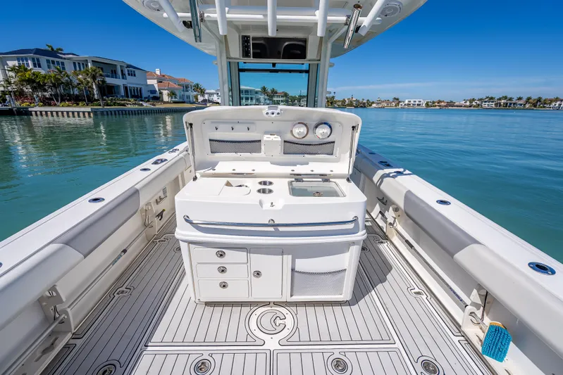 High Voltage Yacht Photos Pics 2013 Boston Whaler 320 Outrage boat interior with fishing station, docked by waterfront homes.