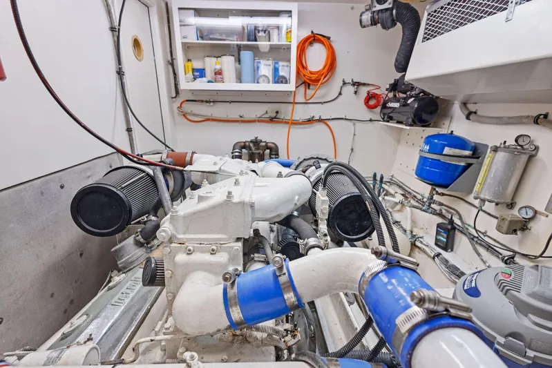 Airwaves Yacht Photos Pics Engine room of 1987 Hatteras 68 Cockpit Motor Yacht, showcasing mechanical components and storage.