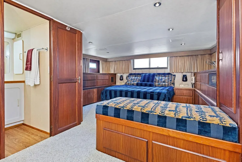 Airwaves Yacht Photos Pics Luxurious bedroom in 1987 Hatteras 68 Cockpit Motor Yacht with elegant wood finishes.
