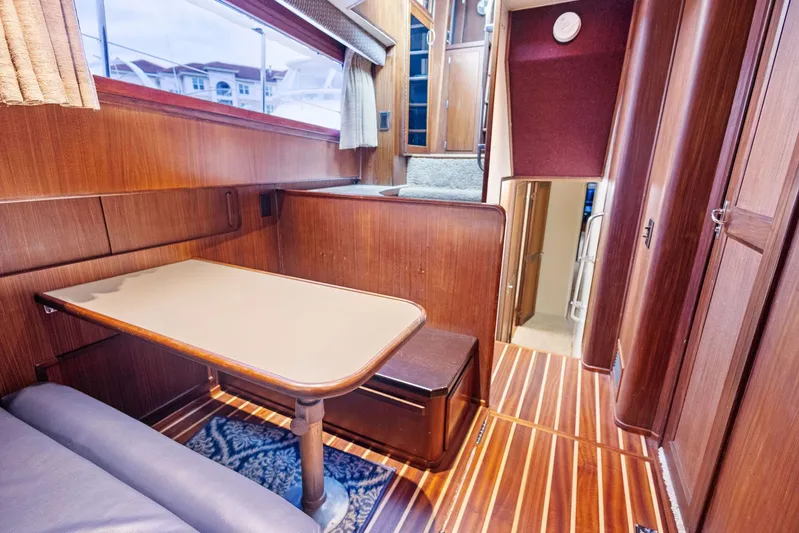 Airwaves Yacht Photos Pics Interior of 1987 Hatteras 68 Cockpit Motor Yacht with wood paneling and dining area.