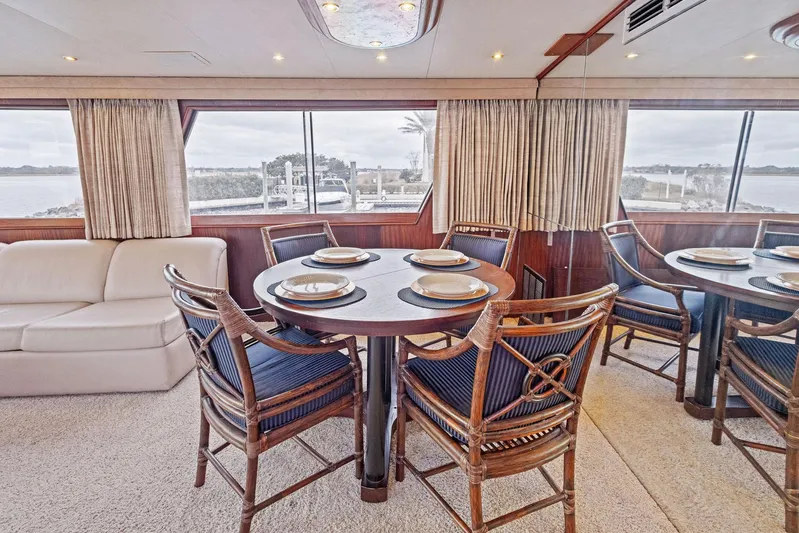 Airwaves Yacht Photos Pics Luxurious dining area in 1987 Hatteras 68 Cockpit Motor Yacht with elegant seating and scenic views.