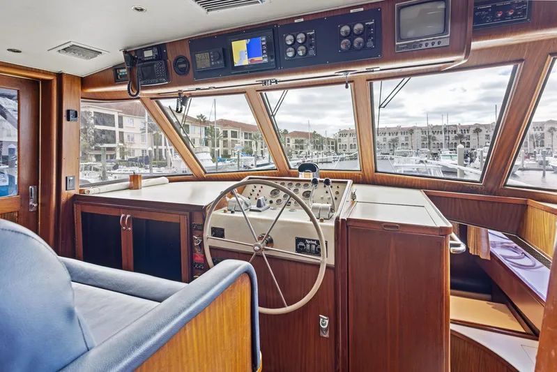 Airwaves Yacht Photos Pics Interior helm of 1987 Hatteras 68 Cockpit Motor Yacht with wooden finish and navigation controls.