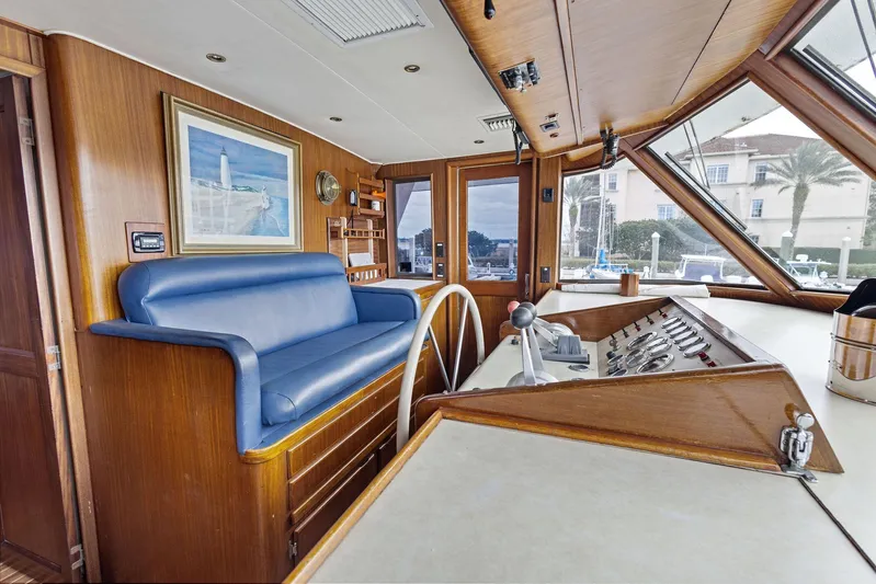Airwaves Yacht Photos Pics Interior of 1987 Hatteras 68 Cockpit Motor Yacht with blue seating and wooden helm.