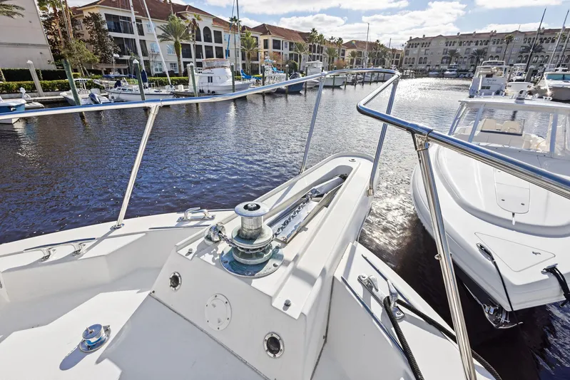 Airwaves Yacht Photos Pics 1987 Hatteras 68 Cockpit Motor Yacht docked in a marina, surrounded by water and boats.