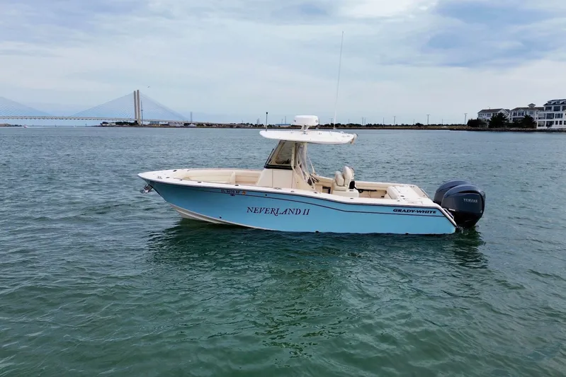 Neverland II Yacht Photos Pics 2022 Grady-White Canyon 271 boat on water, bridge and buildings in background.