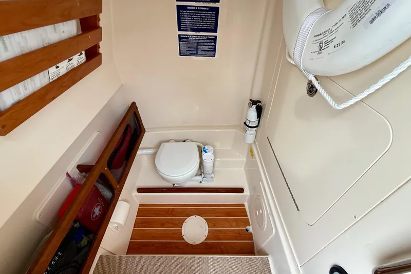 Neverland II Yacht Photos Pics 2022 Grady-White Canyon 271 boat interior with toilet, wooden flooring, and safety equipment.