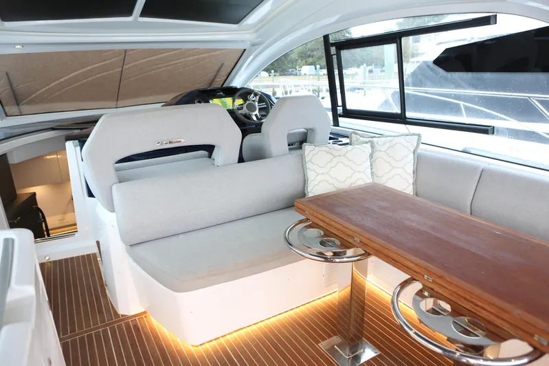 Lucky Lovers Yacht Photos Pics Interior of 2023 Beneteau Gran Turismo 45 yacht with modern seating and wooden table.