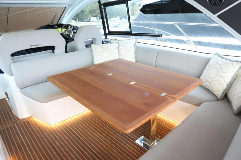Lucky Lovers Yacht Photos Pics Luxurious interior of 2023 Beneteau Gran Turismo 45 yacht with elegant seating and wooden table.