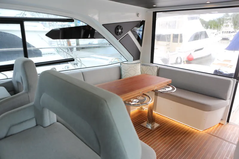 Lucky Lovers Yacht Photos Pics Luxurious interior of 2023 Beneteau Gran Turismo 45 yacht with elegant seating and wooden table.
