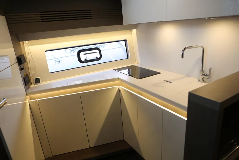 Lucky Lovers Yacht Photos Pics Modern kitchen interior of 2023 Beneteau Gran Turismo 45 yacht, featuring sleek design and lighting.