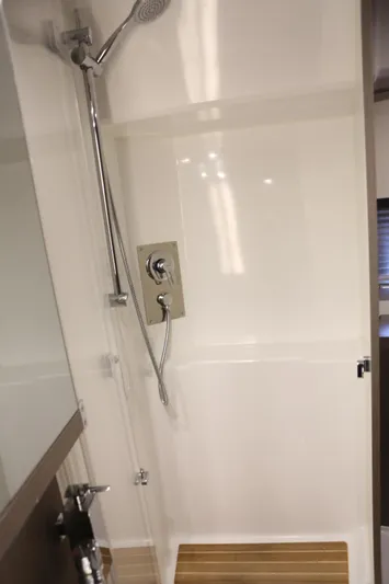 Lucky Lovers Yacht Photos Pics Shower area in 2023 Beneteau Gran Turismo 45 yacht, featuring modern fixtures and wooden flooring.