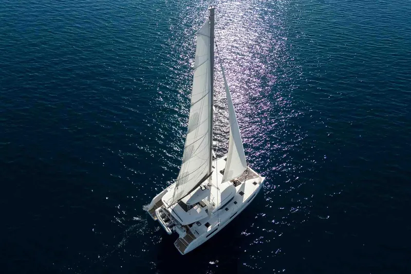 Mare Azul Yacht Photos Pics 2024 Lagoon 46 catamaran sailing on open water under bright sunlight.