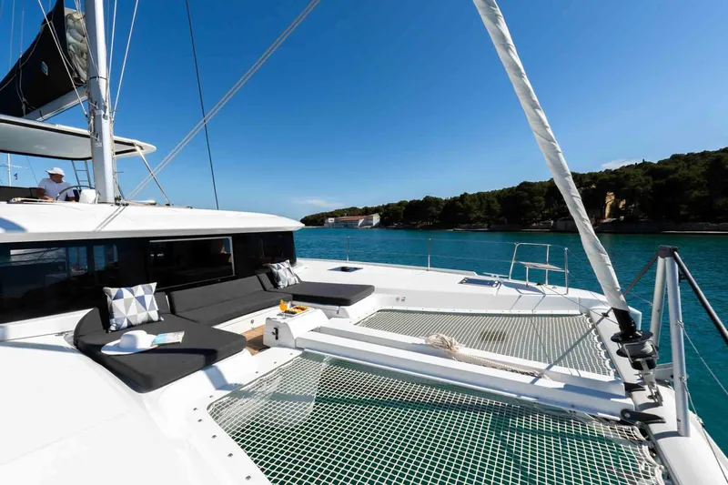Mare Azul Yacht Photos Pics 2024 Lagoon 46 catamaran on serene blue water, featuring spacious deck and netting.