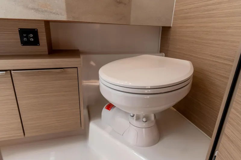 Mare Azul Yacht Photos Pics 2024 Lagoon 46 yacht bathroom with modern toilet and wooden cabinetry.