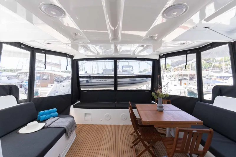 Mare Azul Yacht Photos Pics 2024 Lagoon 46 yacht interior with seating and dining area, docked at marina.