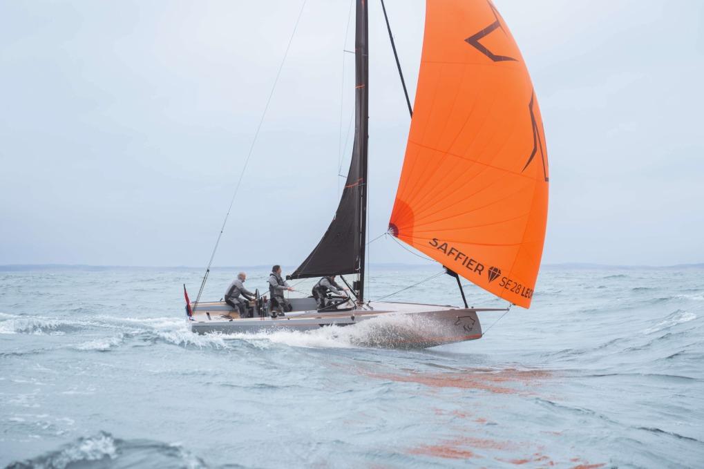 Saffier SE 28 Leopard 2026 sailing on open water with vibrant orange sail.