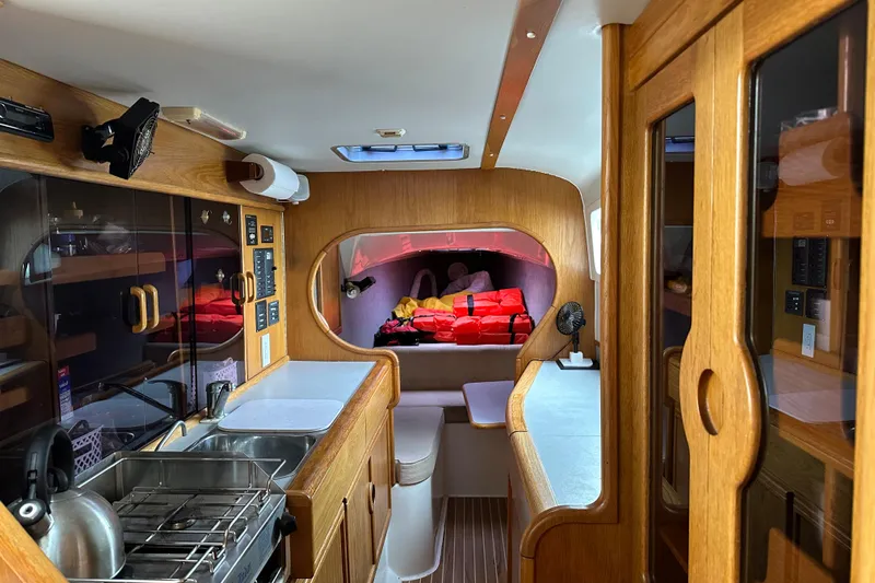 Makani Yacht Photos Pics Interior of 2008 Seawind 1000 XL catamaran with wood finish and compact kitchen.