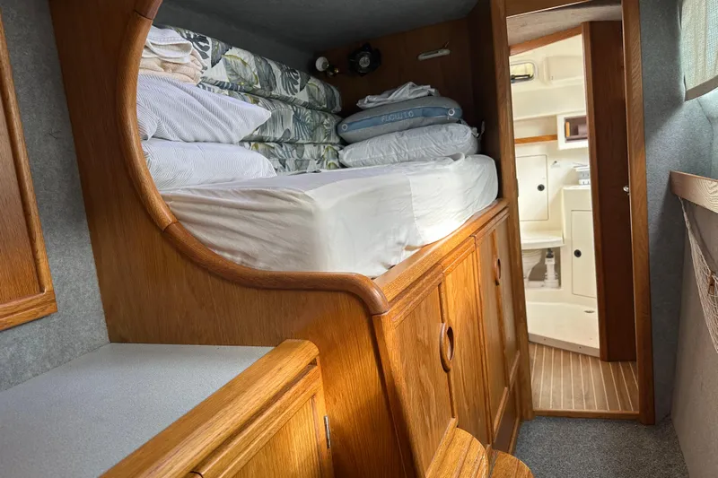 Makani Yacht Photos Pics Cozy cabin interior of 2008 Seawind 1000 XL catamaran with wooden furnishings and bedding.