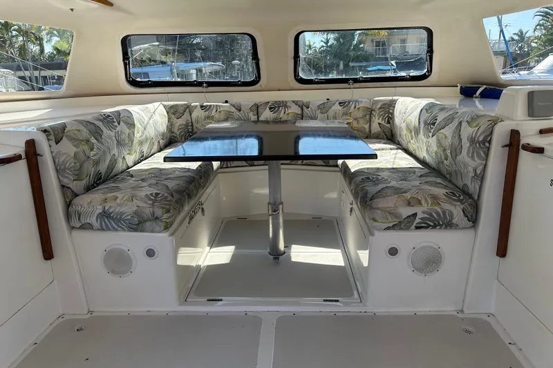 Makani Yacht Photos Pics Interior of 2008 Seawind 1000 XL catamaran with tropical-patterned seating and central table.