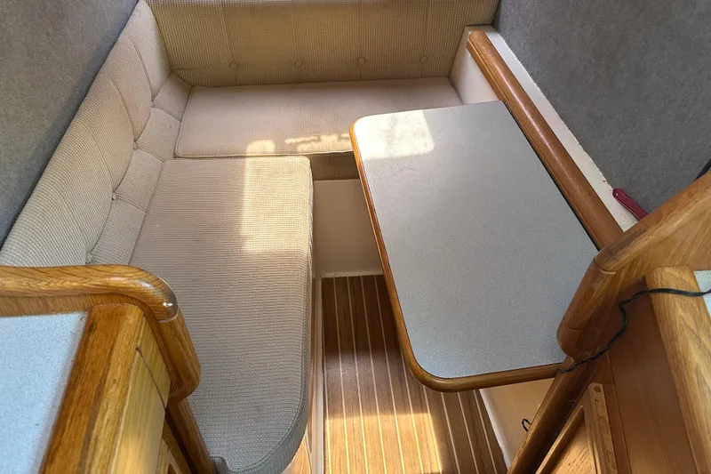 Makani Yacht Photos Pics Cozy interior of 2008 Seawind 1000 XL catamaran with cushioned seating and wooden accents.