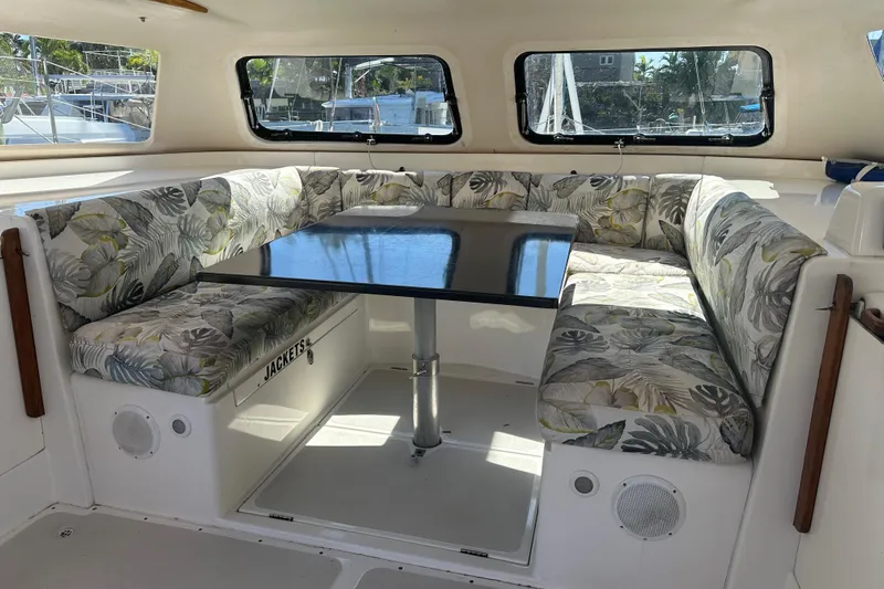 Makani Yacht Photos Pics Interior of 2008 Seawind 1000 XL catamaran with floral-patterned seating and a central table.